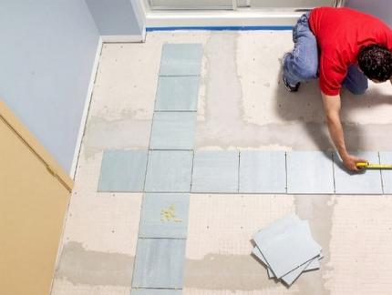 Laying tiles on the floor in the bathroom and toilet
